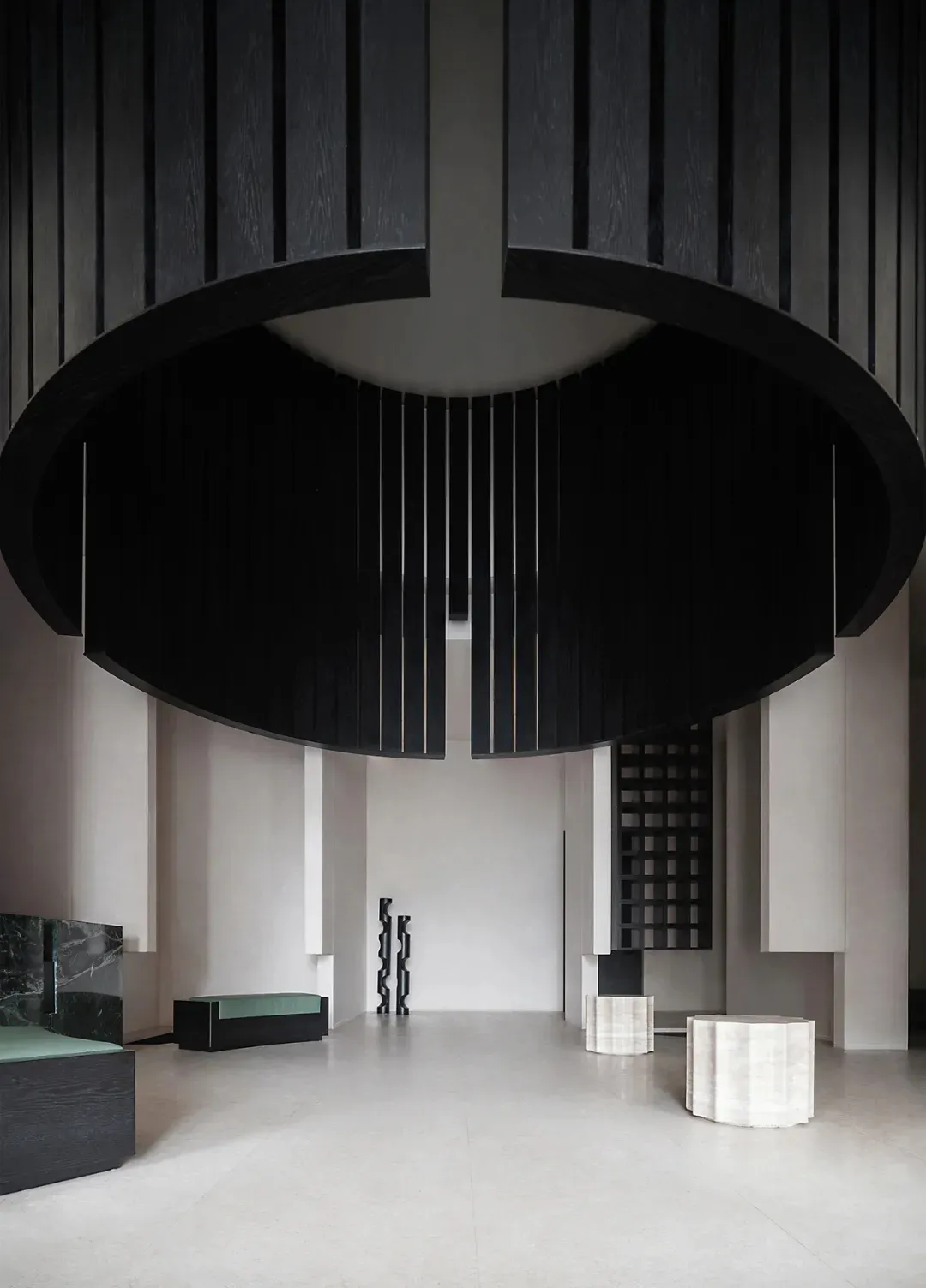Modern minimalist lobby interior with black wood, marble, and concrete tiles.