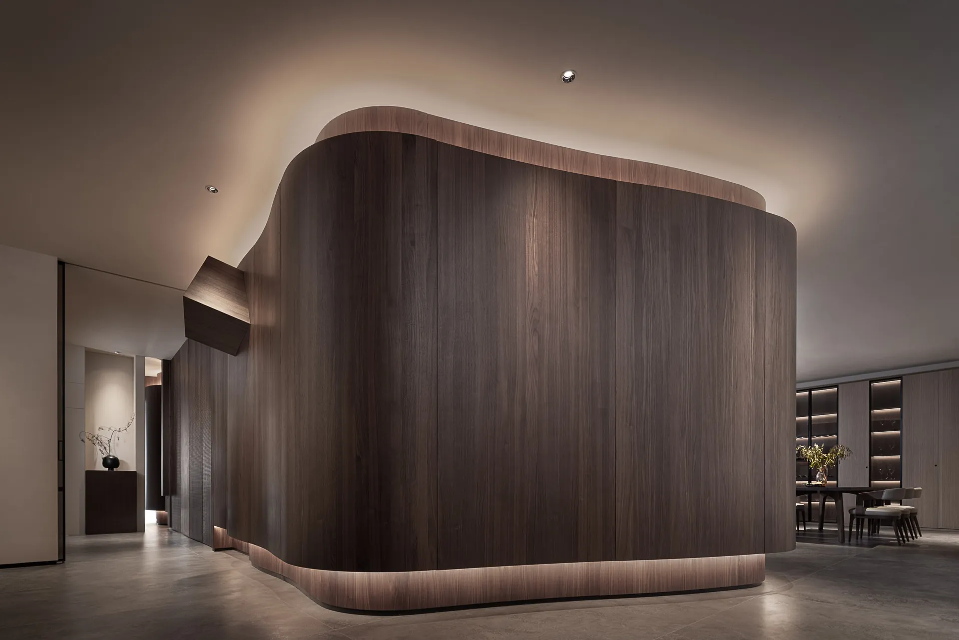 A modern reception desk featuring dark wood with subtle lighting accents, emphasizing its sleek and sophisticated design.