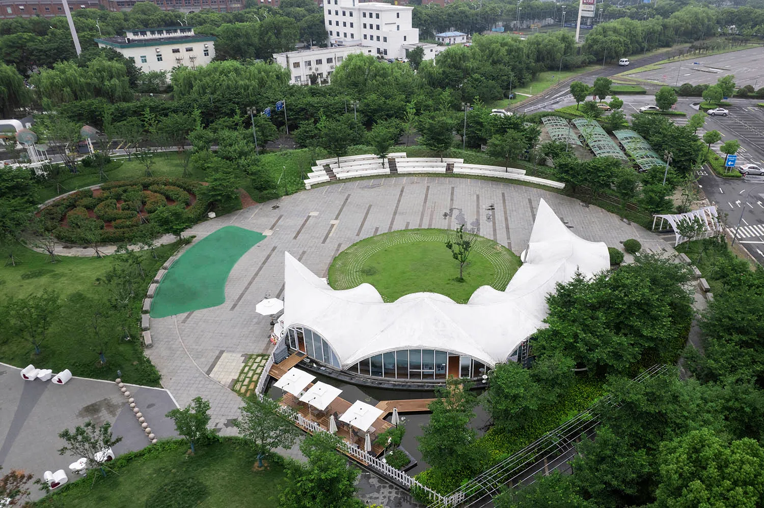 一座公園,內有雕塑、混凝土帳篷與綠意植栽