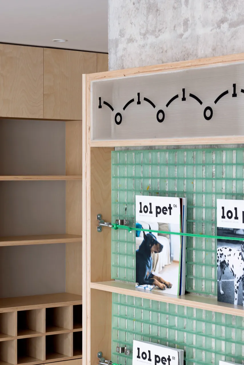 A glass magazine display shelf featuring a clock and magazines.