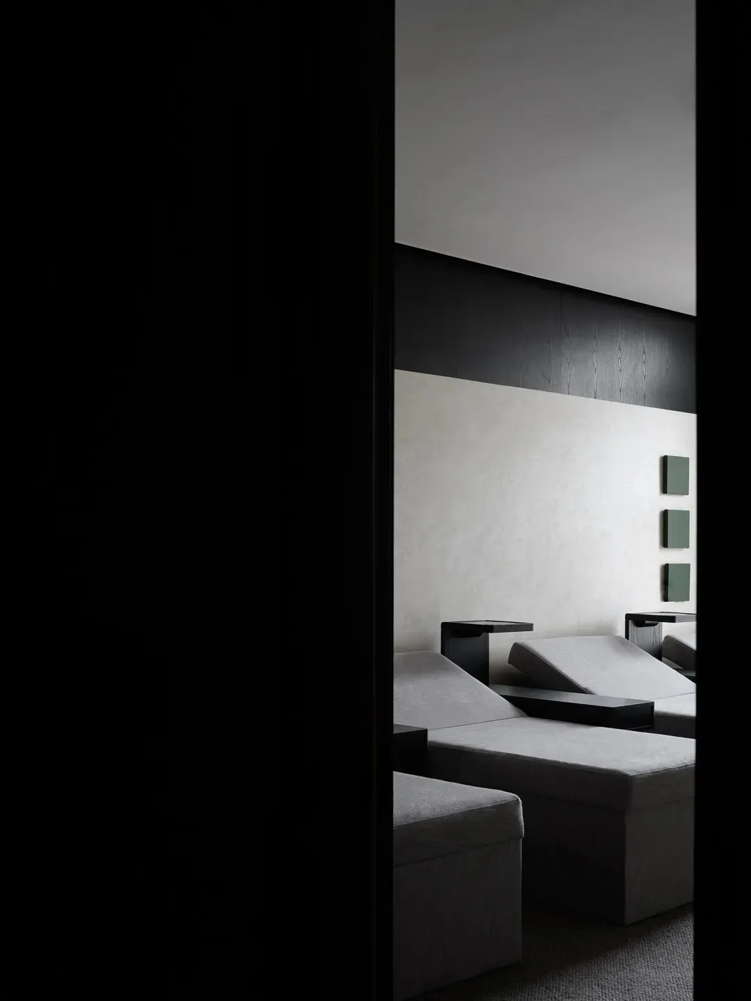 A minimalist living room featuring textured wall paper and sleek, modern furniture.