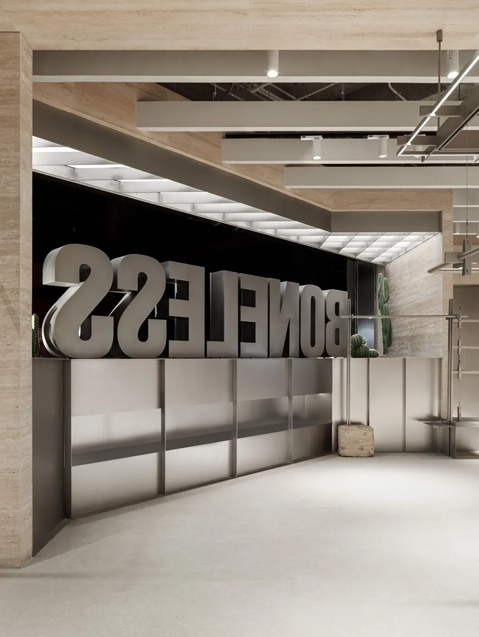 Modern, minimalist office space with large metallic letters spelling 'BONELLES' against a black background, complemented by c