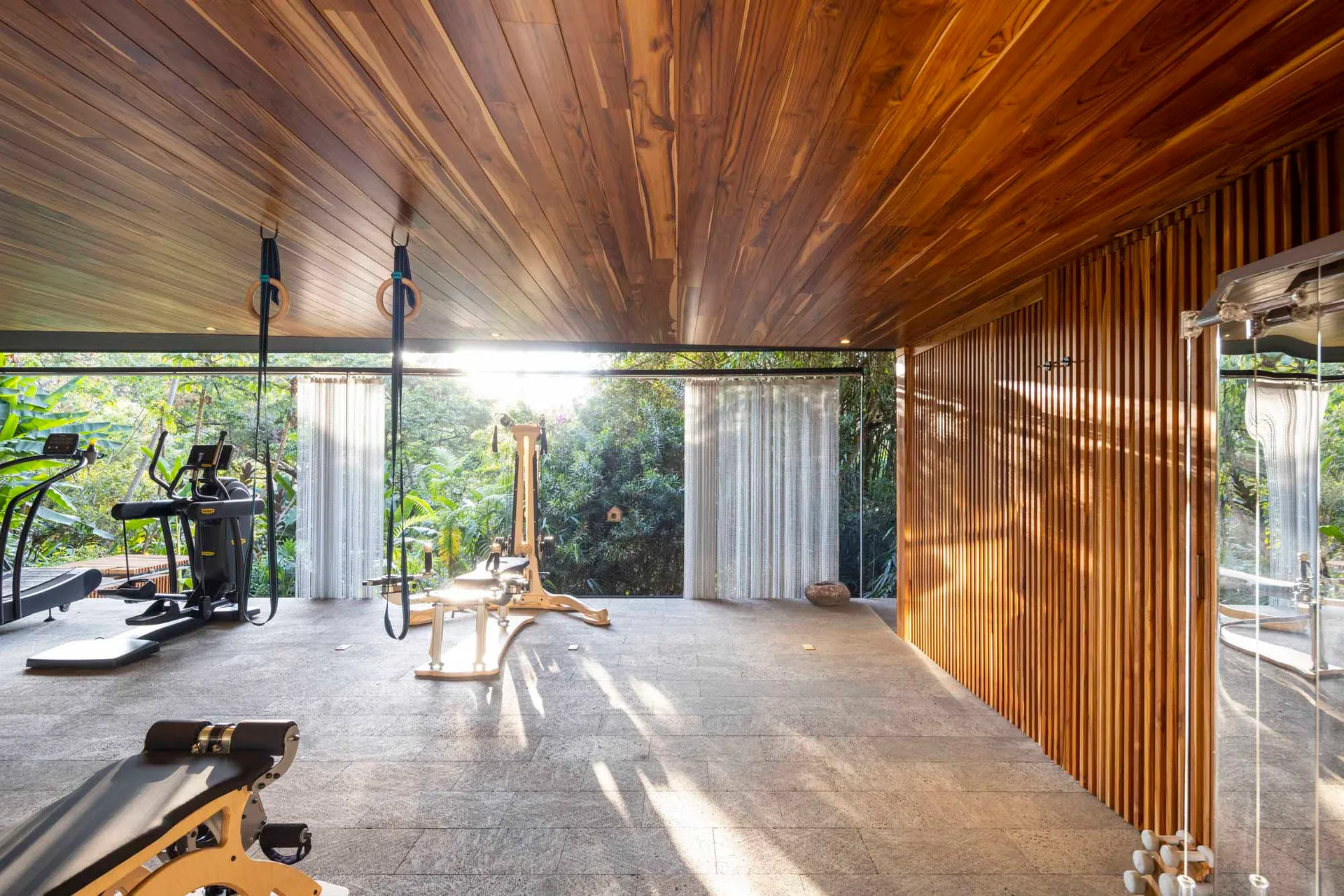 A modern minimalist gym with wooden elements and exercise equipment.