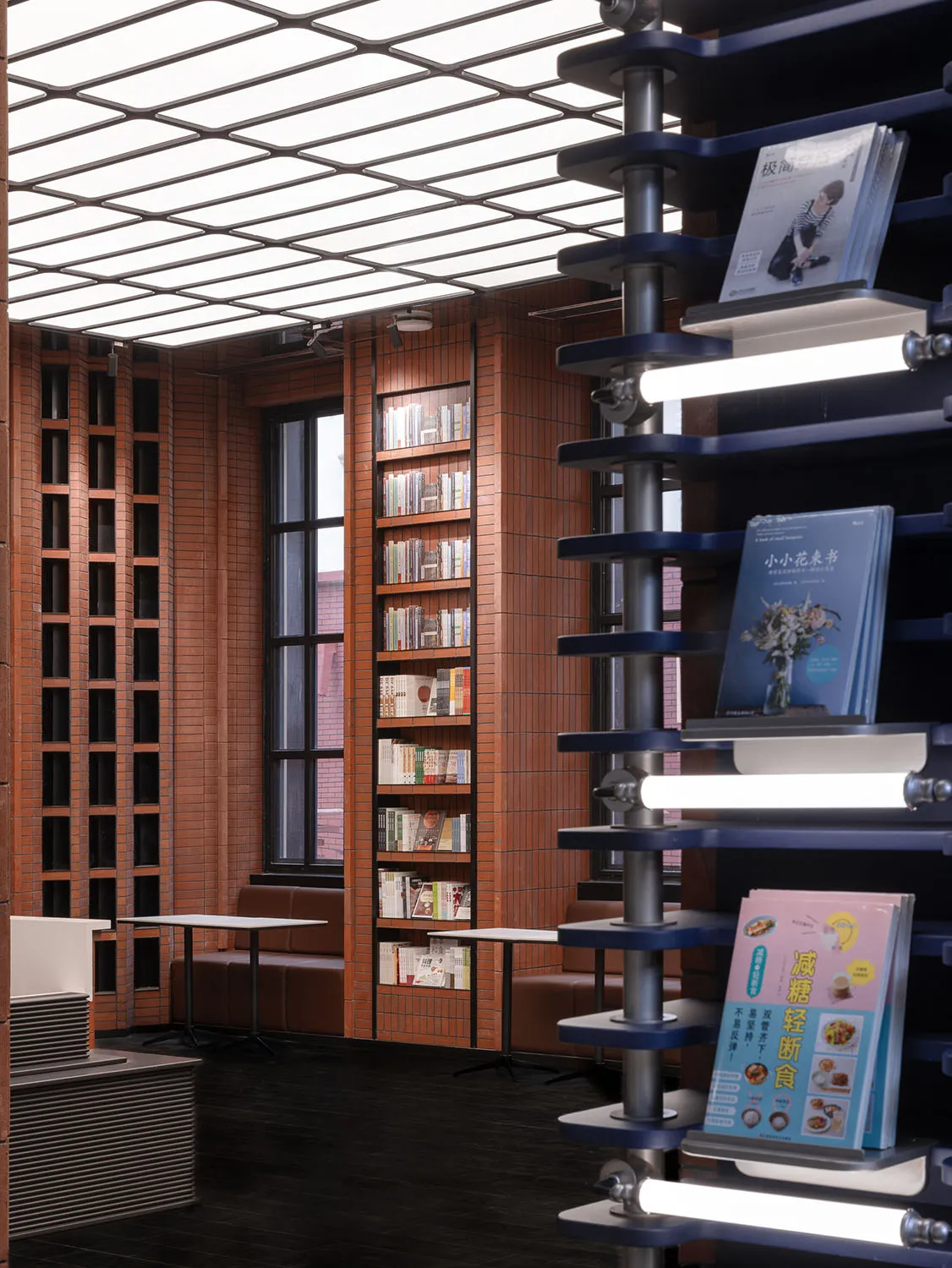 Industrially designed library with exposed brick walls, metal shelves, and glass windows.
