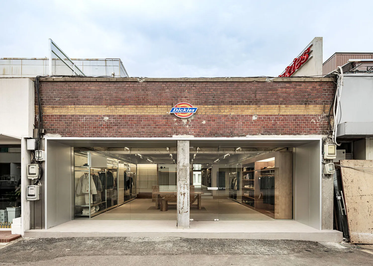 Modern clothing store with brick facade, glass display windows, and concrete interior