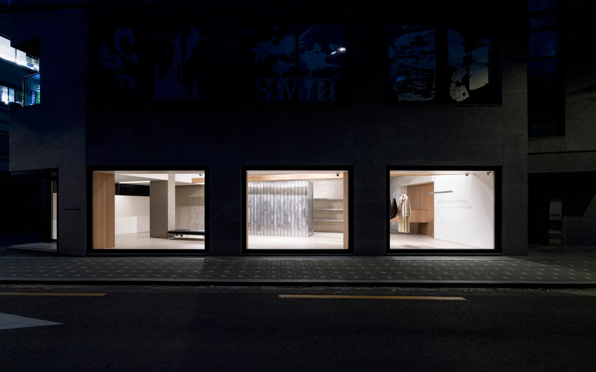 夜晚從內部照亮的現代零售店面,展現簡約設計元素與金屬窗櫥展示。
