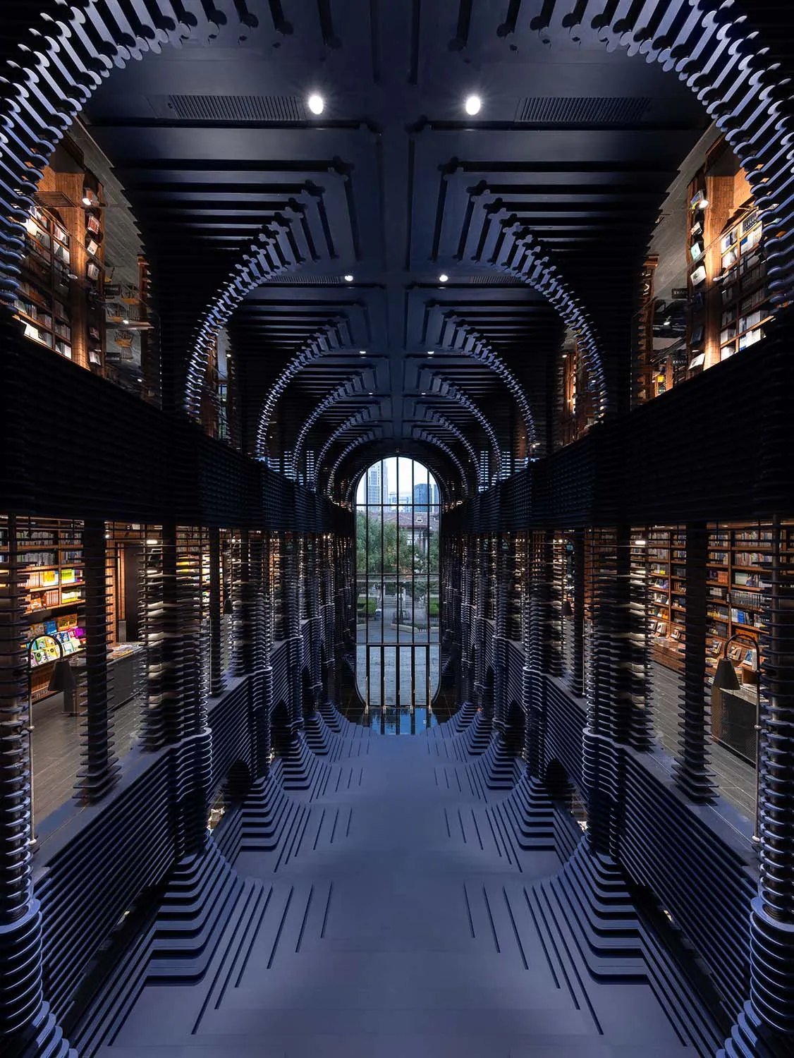 An industrial-style library with metal bookshelves and a mirrored floor.
