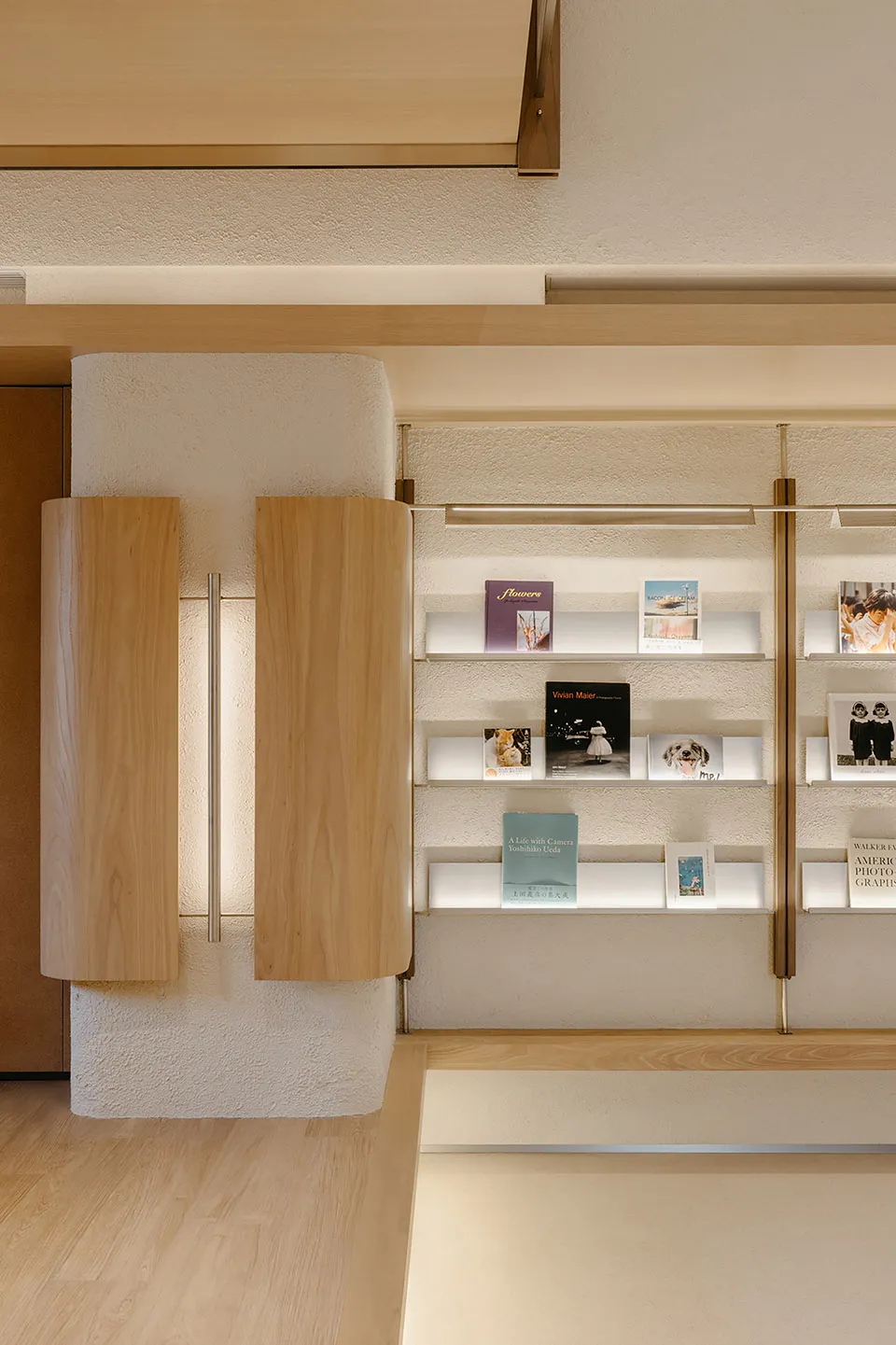 A modern bookstore featuring wooden shelves, plaster walls, and glass displays