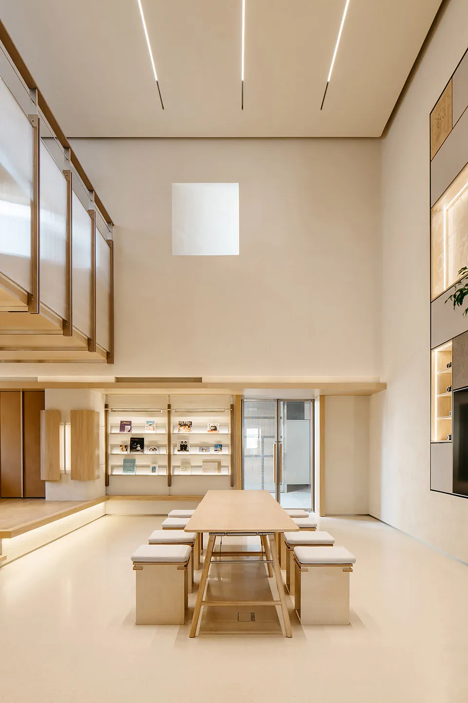 A minimalist modern library with wooden shelving and a large window