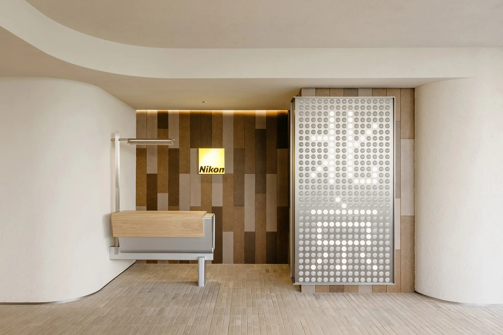 A modern office interior featuring minimalist design elements such as wood, metal, and textured tiles.