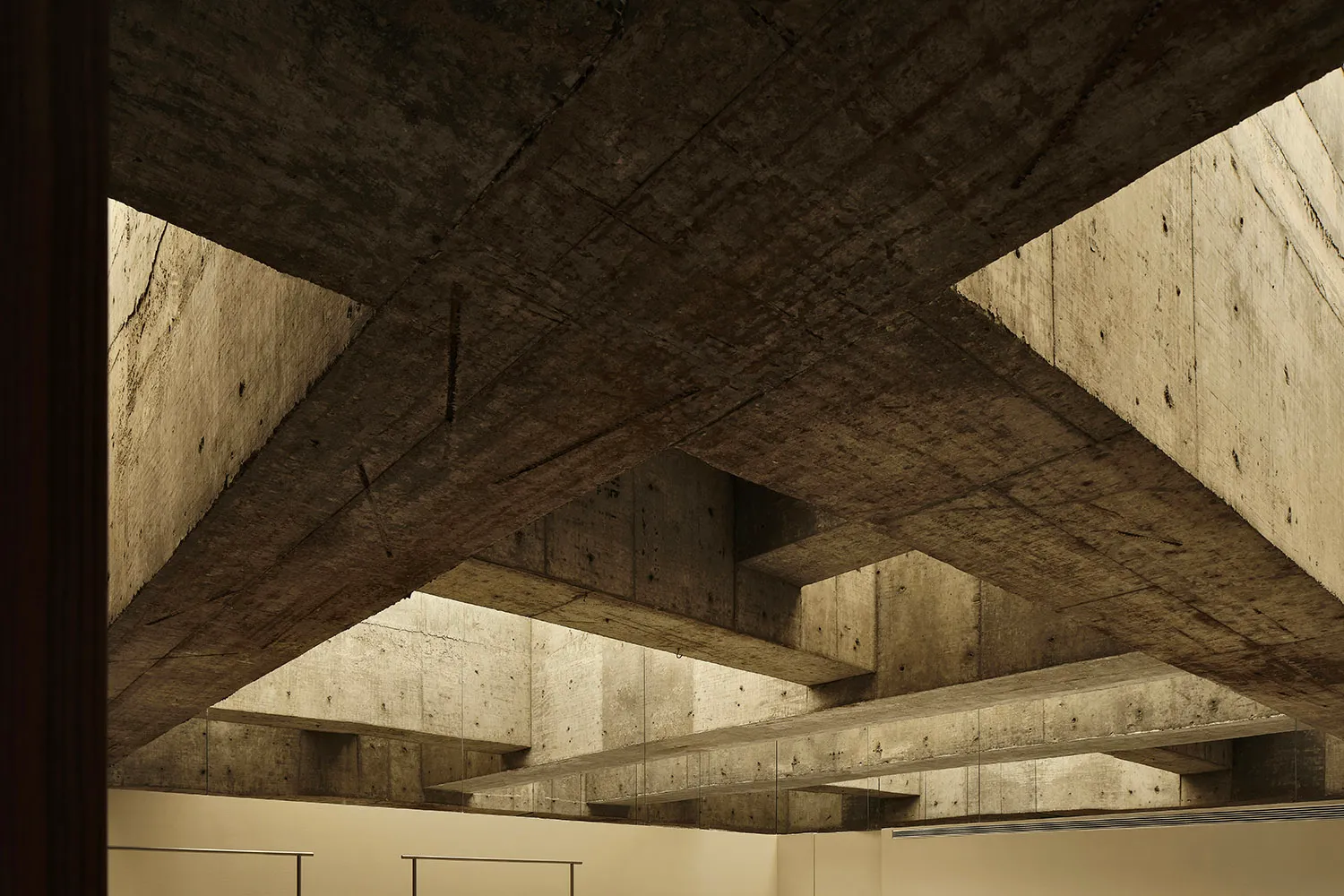 An interior space with modern design, featuring concrete beams and walls.