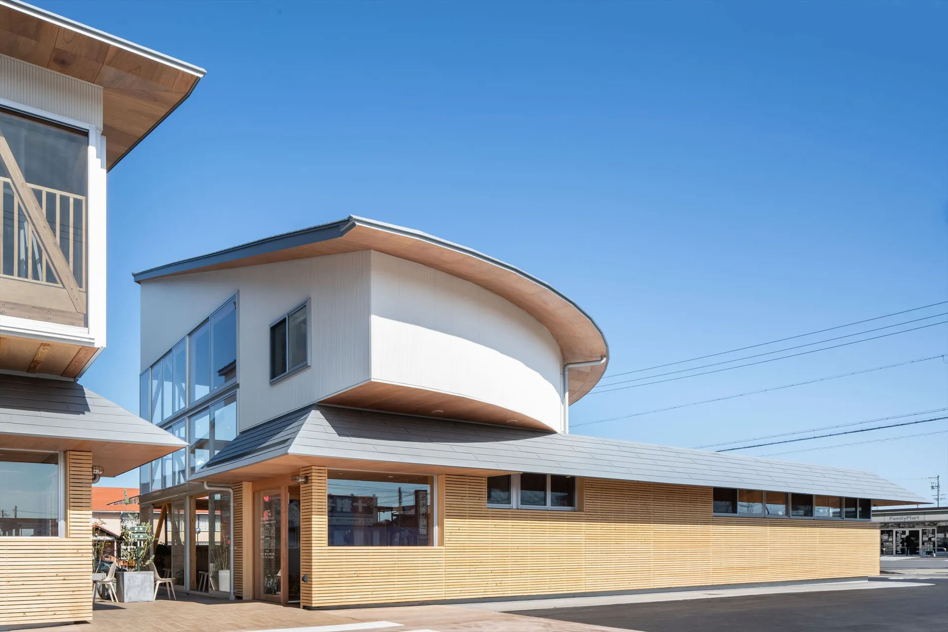 現代店面建築採用金屬包覆外觀,搭配大型玻璃窗與弧形屋頂設計。