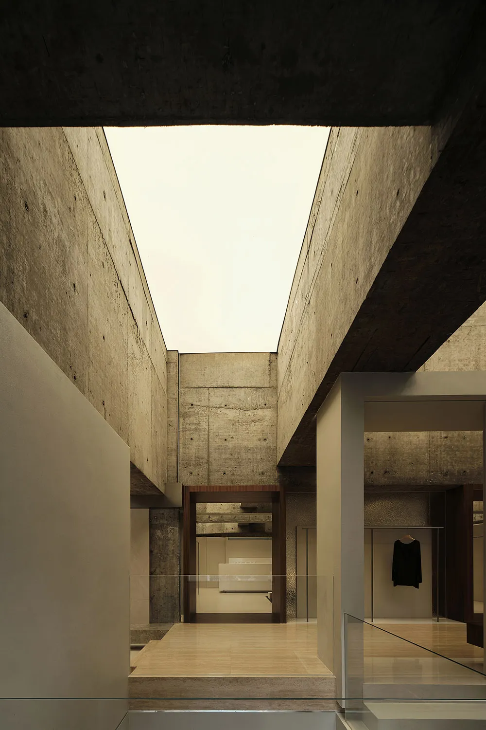 Modern minimalist interior design featuring concrete walls and open ceiling space.