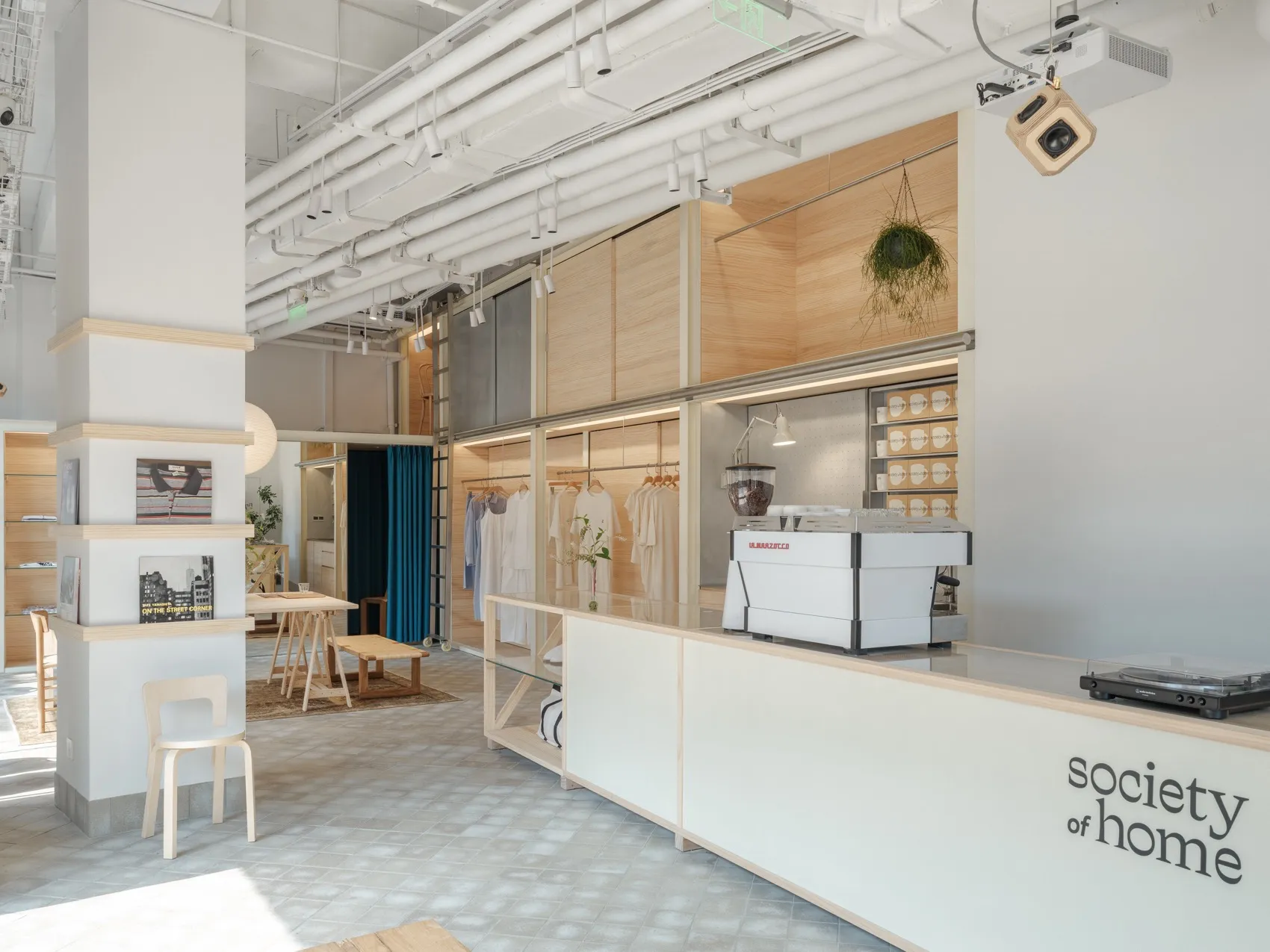 Modern coffee shop interior featuring wooden and concrete materials with a minimalist design aesthetic.