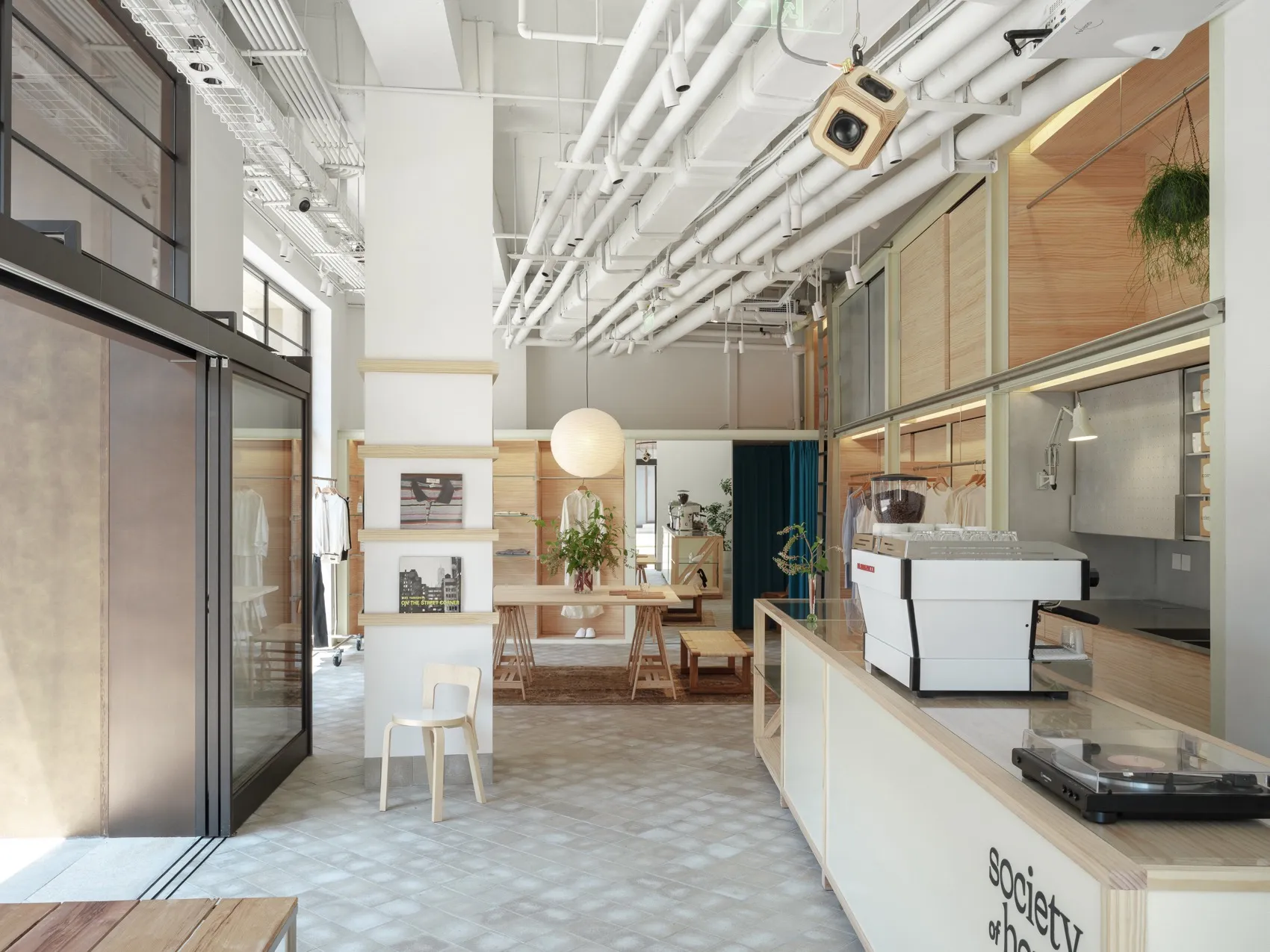 A modern minimalist coffee shop with wood and white materials and a clean, open layout.