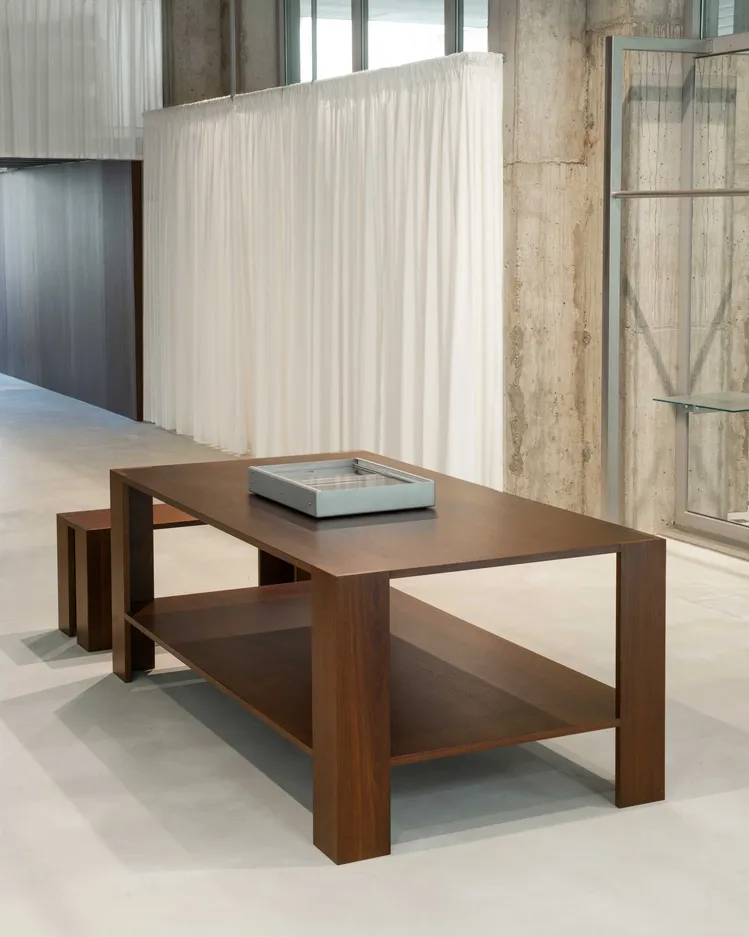 Modern coffee table with wooden frame and ceramic top on a wooden floor