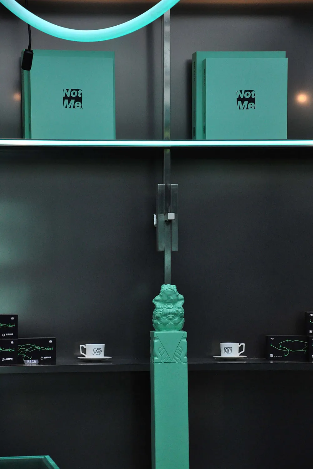 A modern bookstore display featuring turquoise book covers and white coffee cups.
