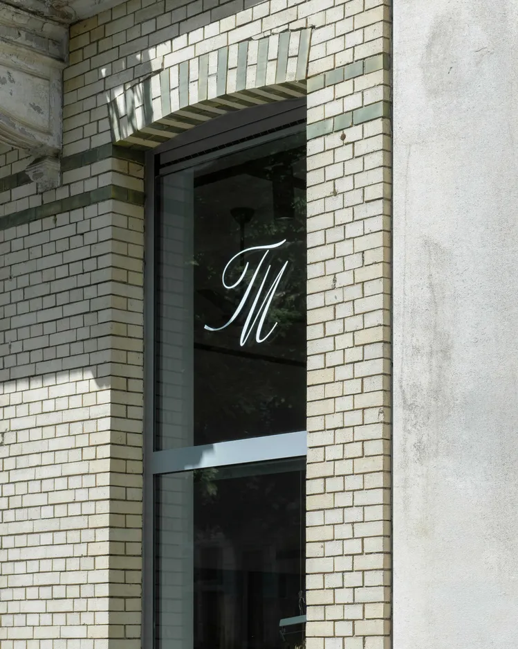 A modern brick facade with the letter 'M' displayed.