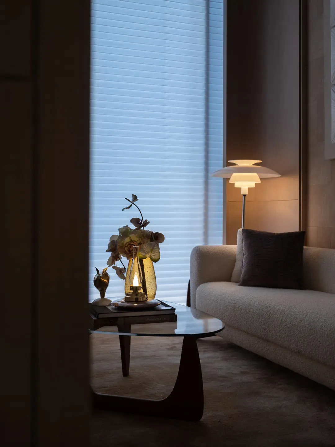 A cozy and contemporary living room featuring modern furniture, a floor lamp, and a glass table.