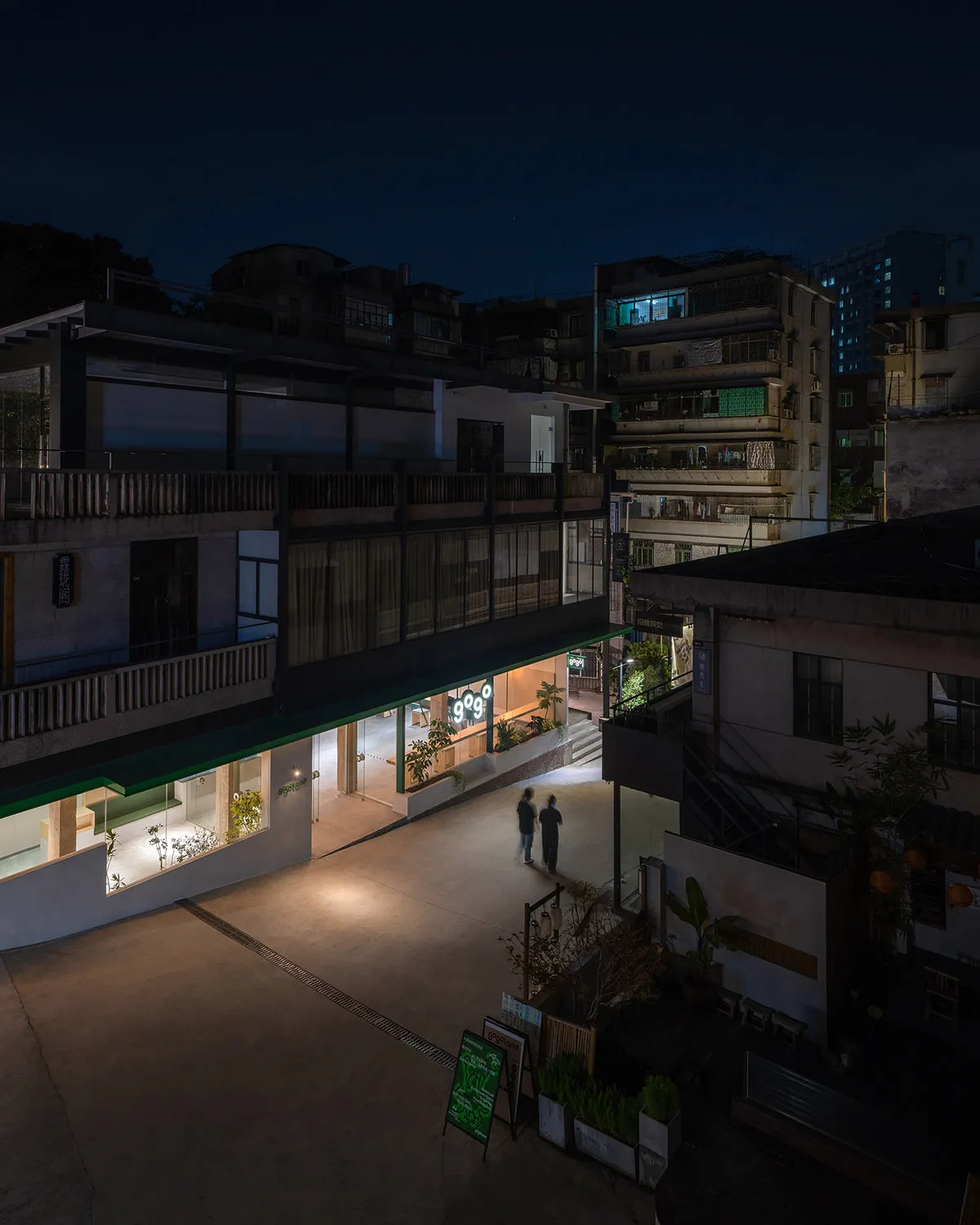 夜晚的現代餐廳混凝土外觀,搭配玻璃店面與鋼材細節。