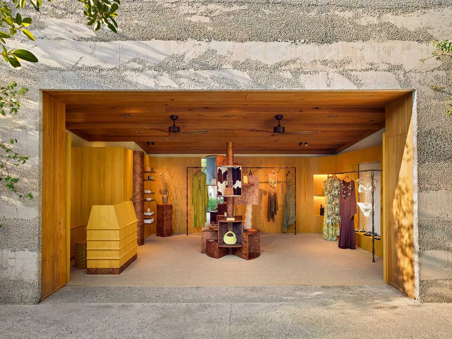 A wooden retail store interior with clothing racks and display shelves.