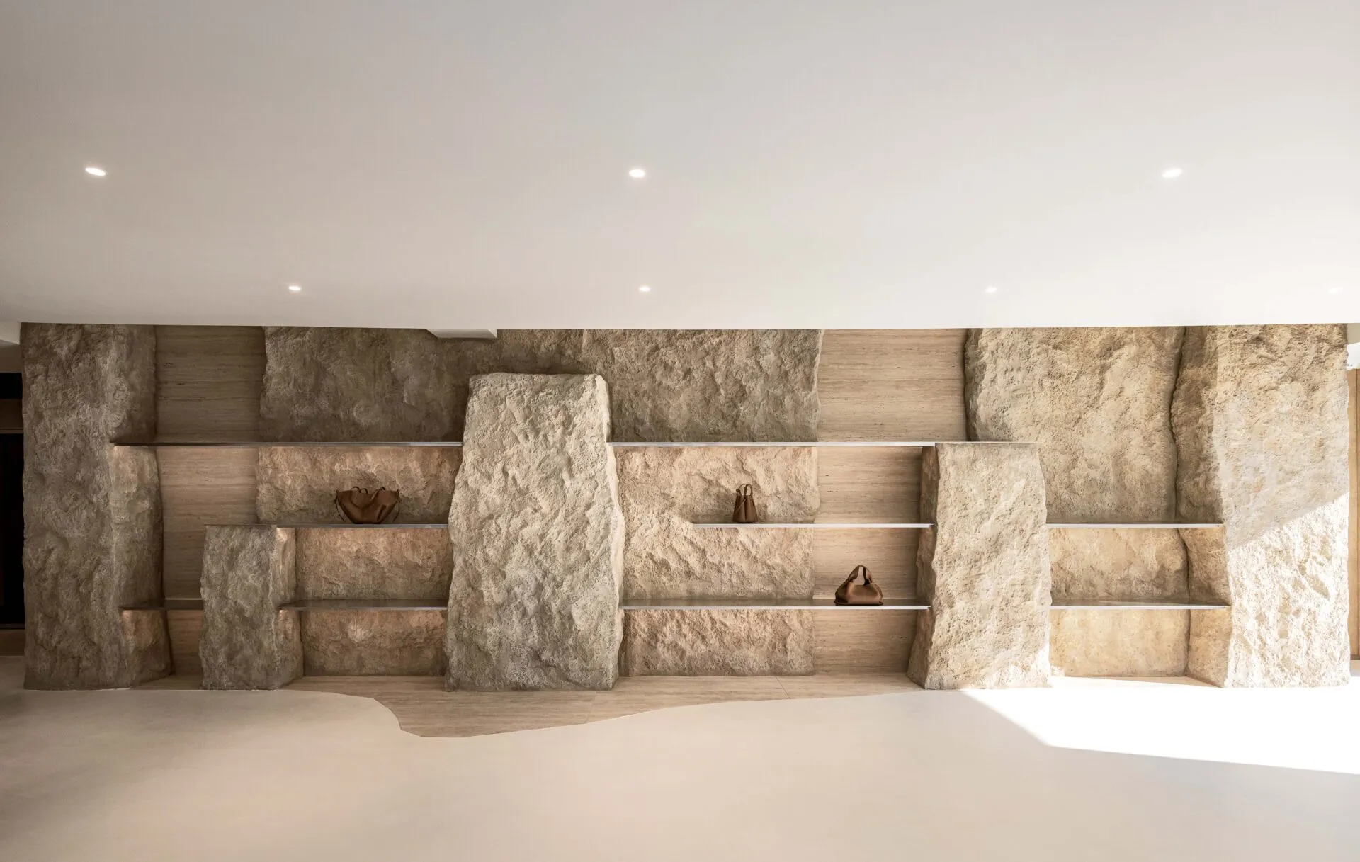 A retail space featuring a natural stone display wall with shelves.
