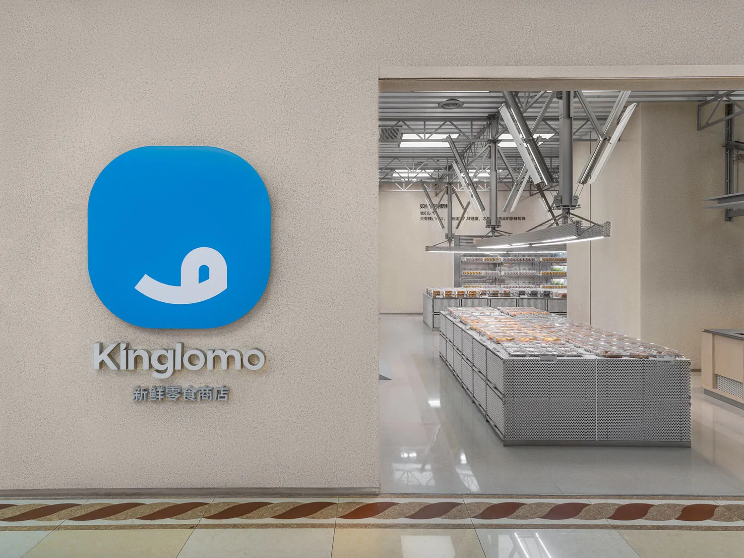 Modern design of a food store with a blue branding sign on the wall and a view into the store's shelves.