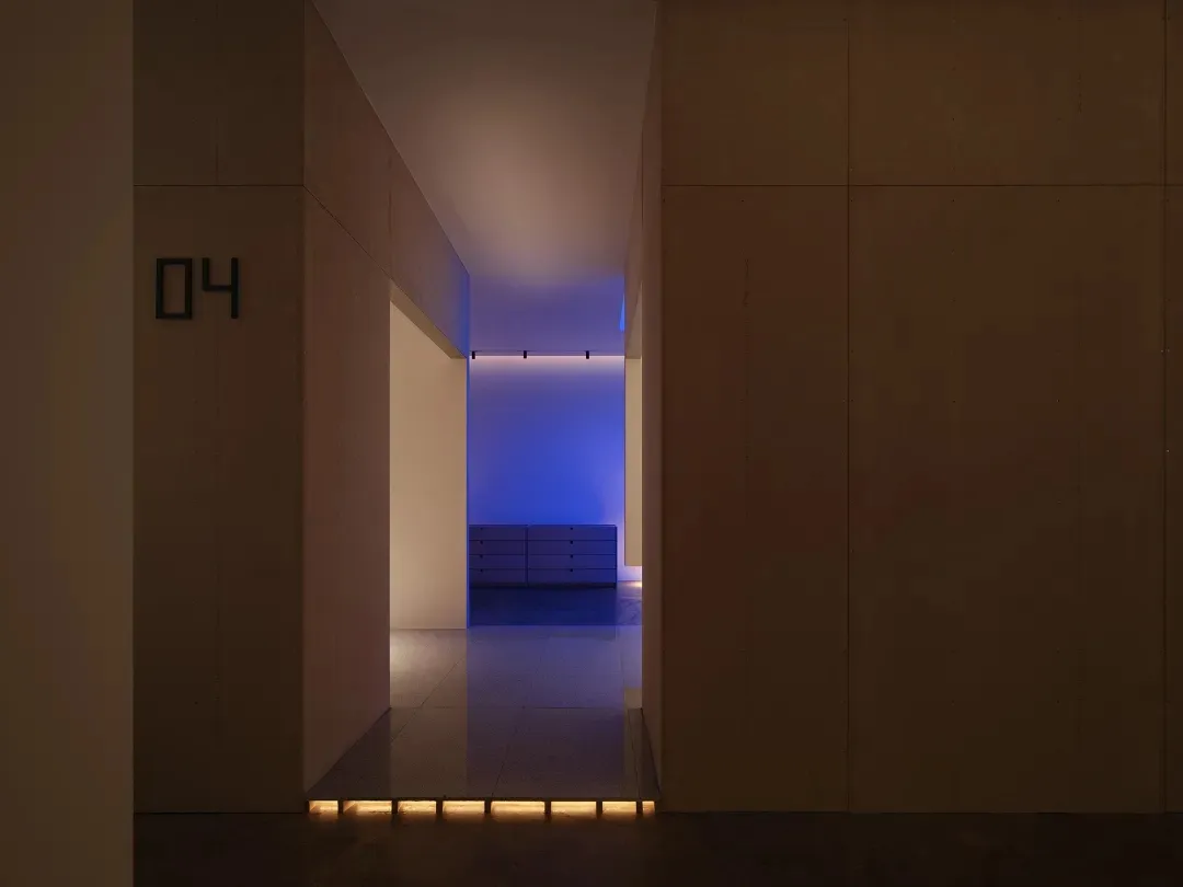 A minimalist hallway with modern lighting fixtures, clean lines, and wood walls.