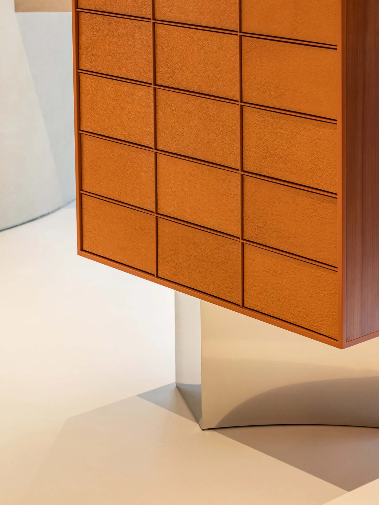 A modern minimalist cabinet with orange leather panels.