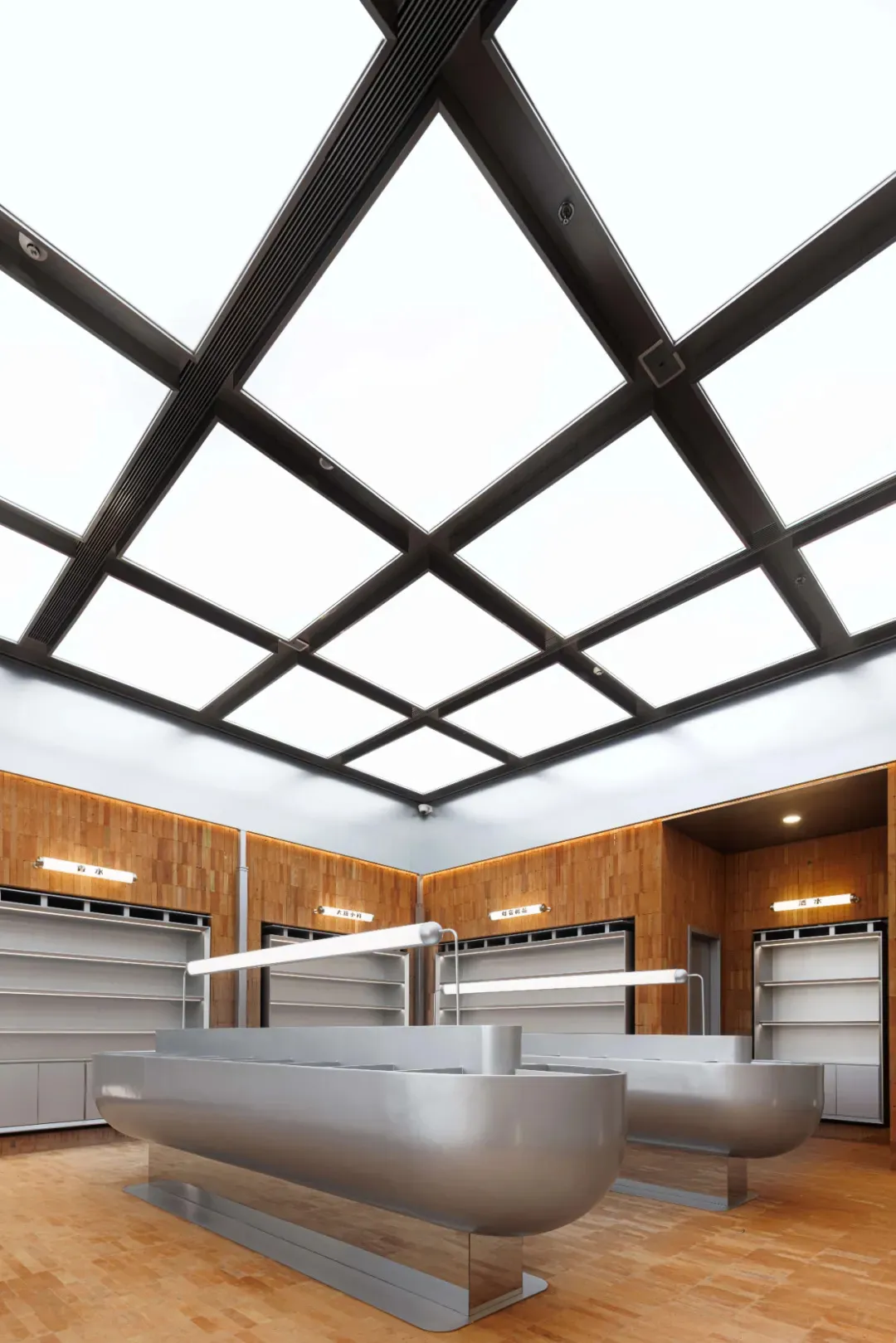 Modern, minimalist supermarket checkout counter with metallic surfaces and wooden accents.