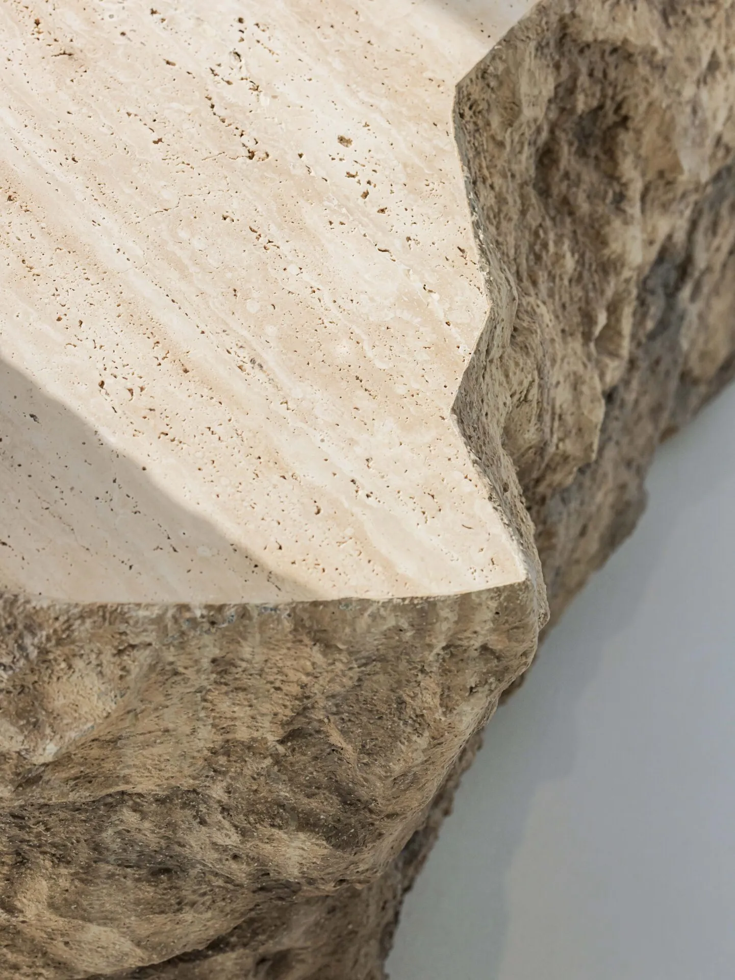 A close-up view of a stone architectural detail showing its textured surface and edges.