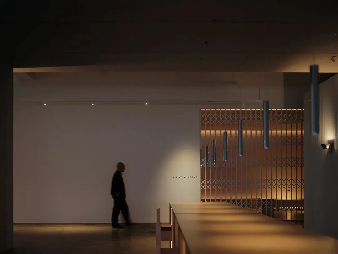 簡約風格的餐廳室內,搭配木質餐桌、現代燈具,以及金屬格柵牆面。