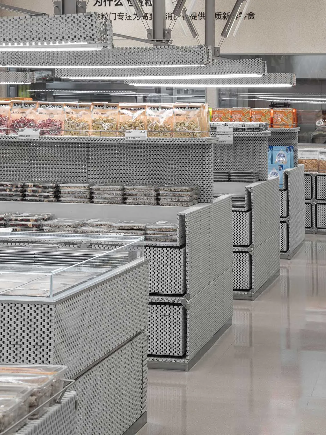 A modern supermarket with metallic shelves and illuminated displays.