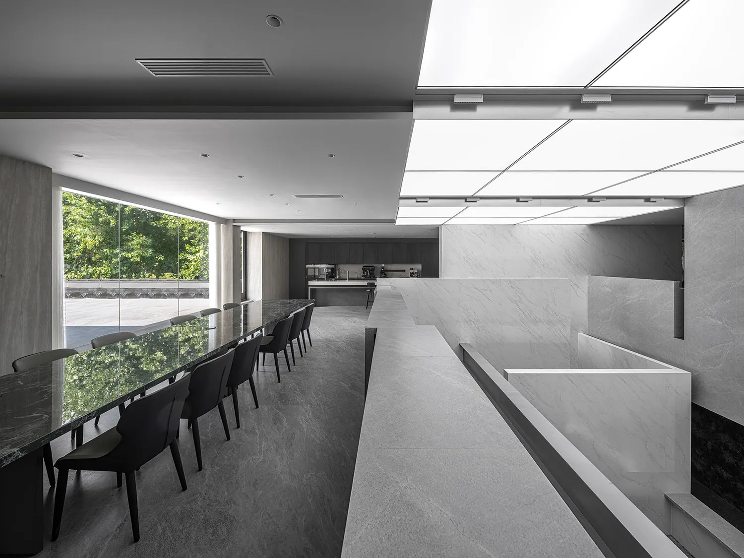 Modern conference room with long table and chairs, marble floor and walls, and ceiling lights.