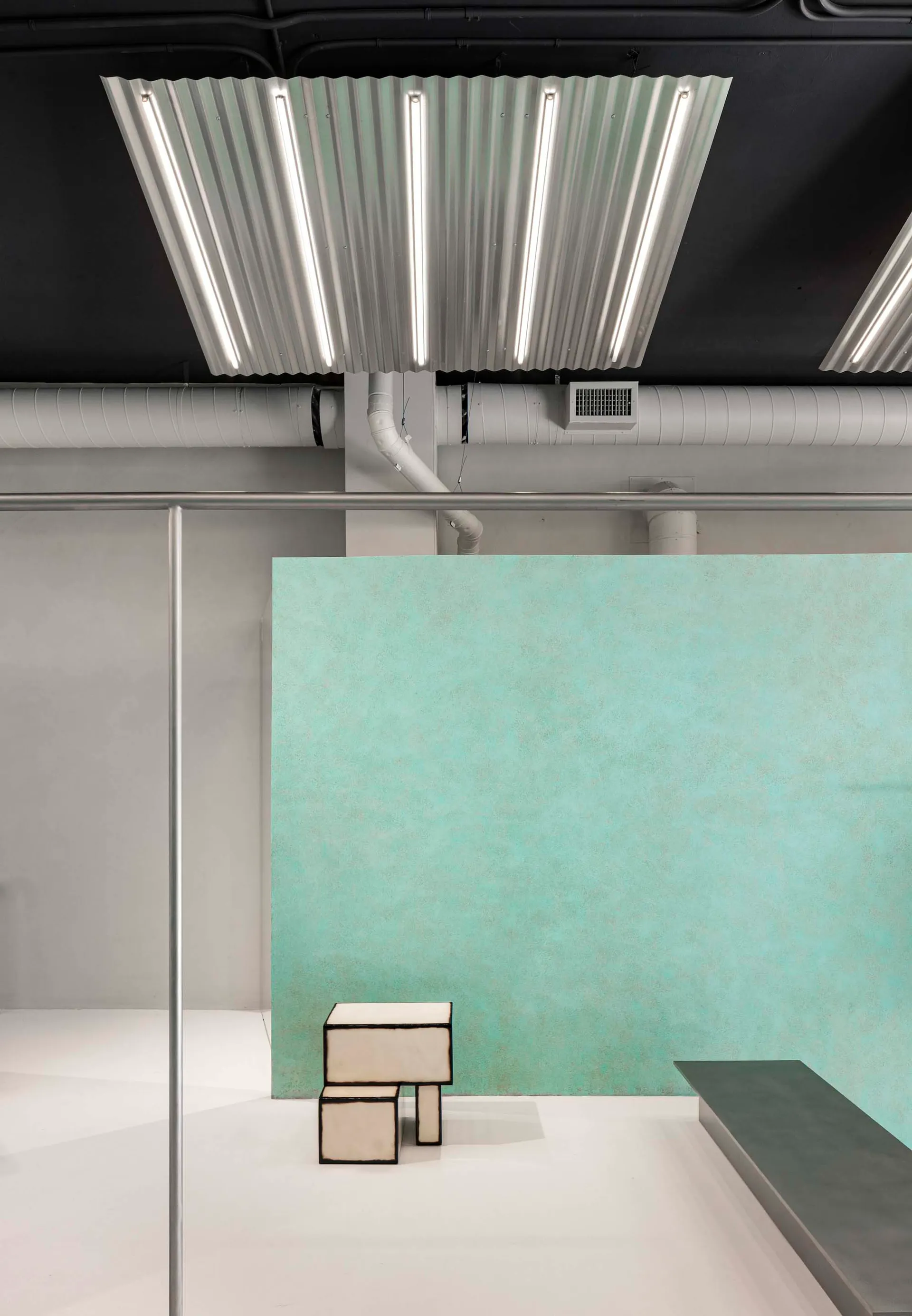 A minimalist interior with concrete walls and a bar area.