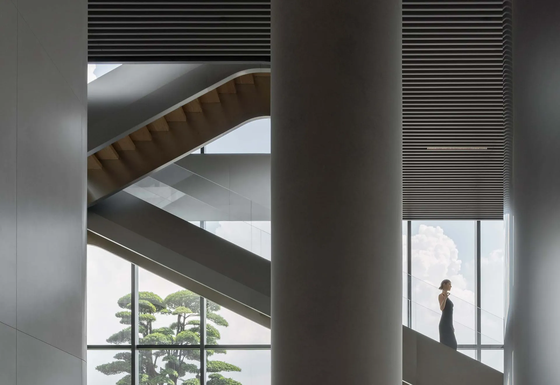 A modern interior design open space with a curved staircase and natural light.