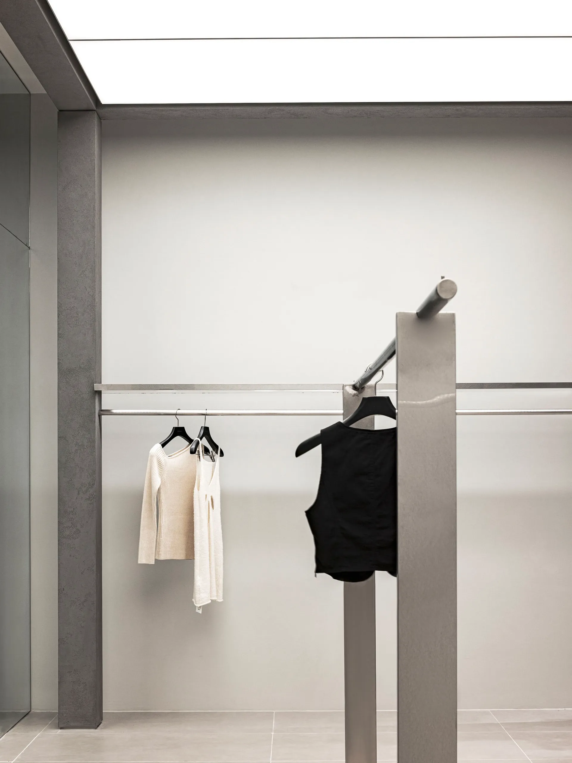 Modern clothing store interior featuring metal bars for clothing display.