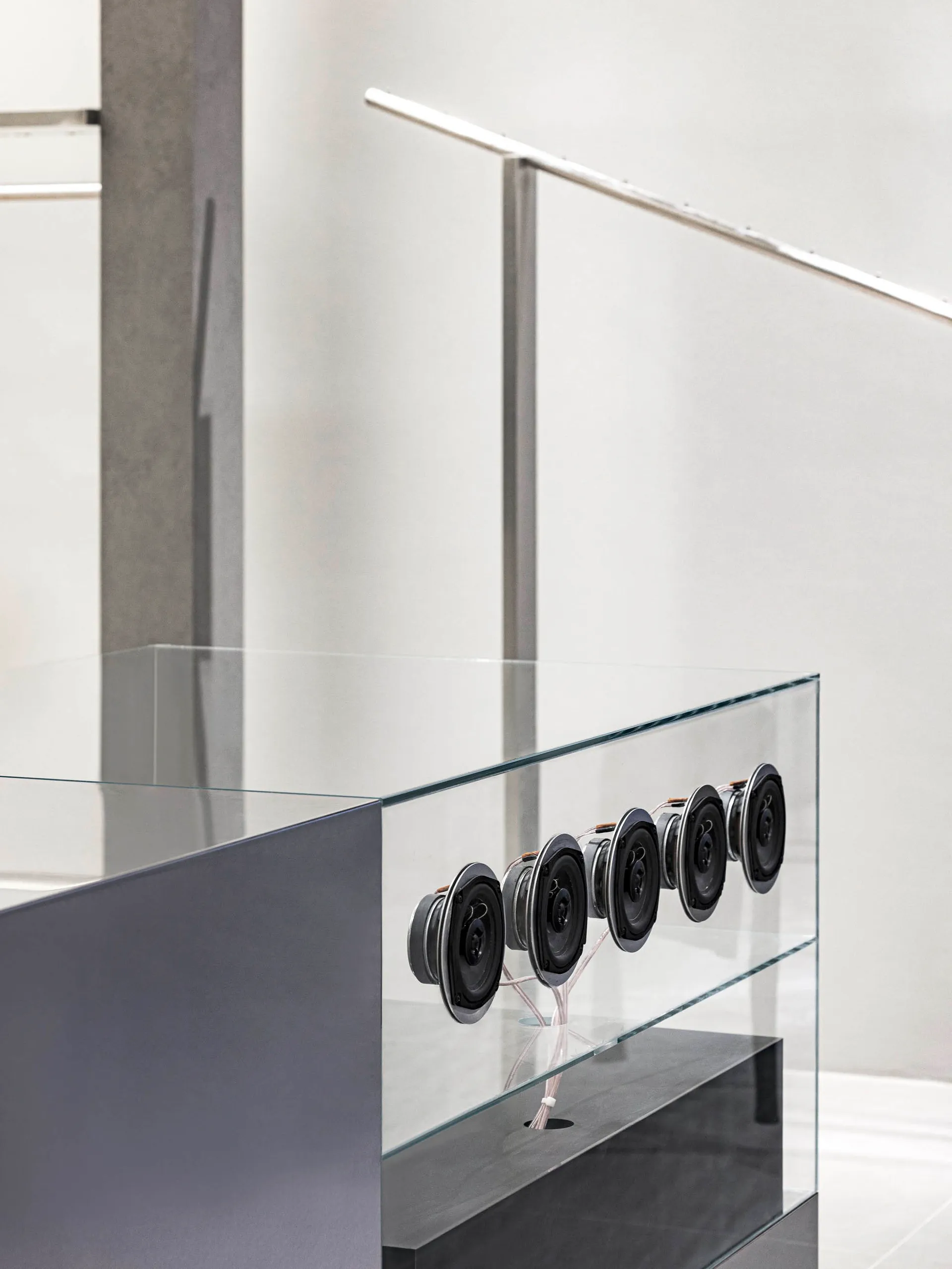 A modern interior space featuring a glass balustrade with a minimalist design.