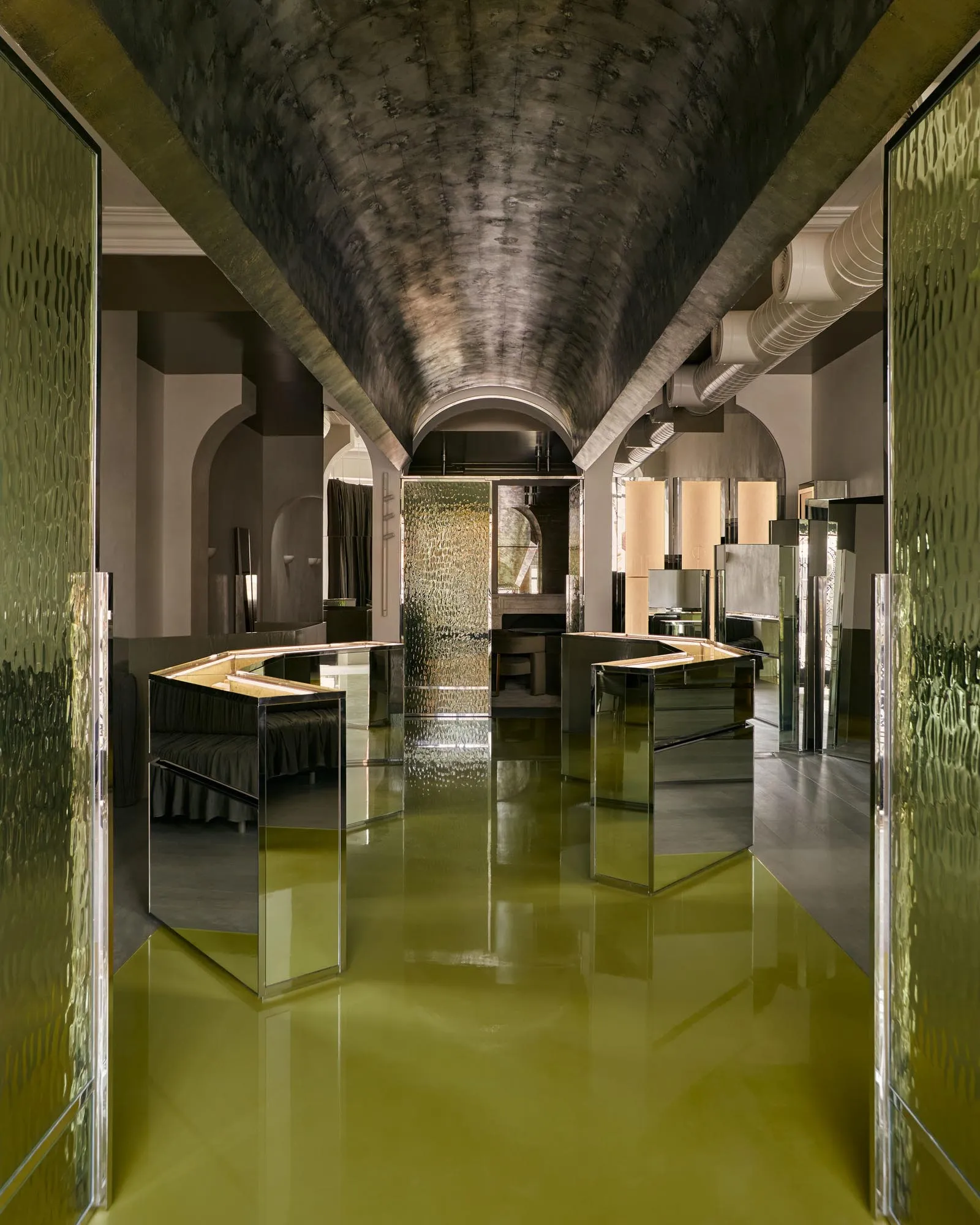 A modern retail space featuring a glass counter and reflective surfaces.