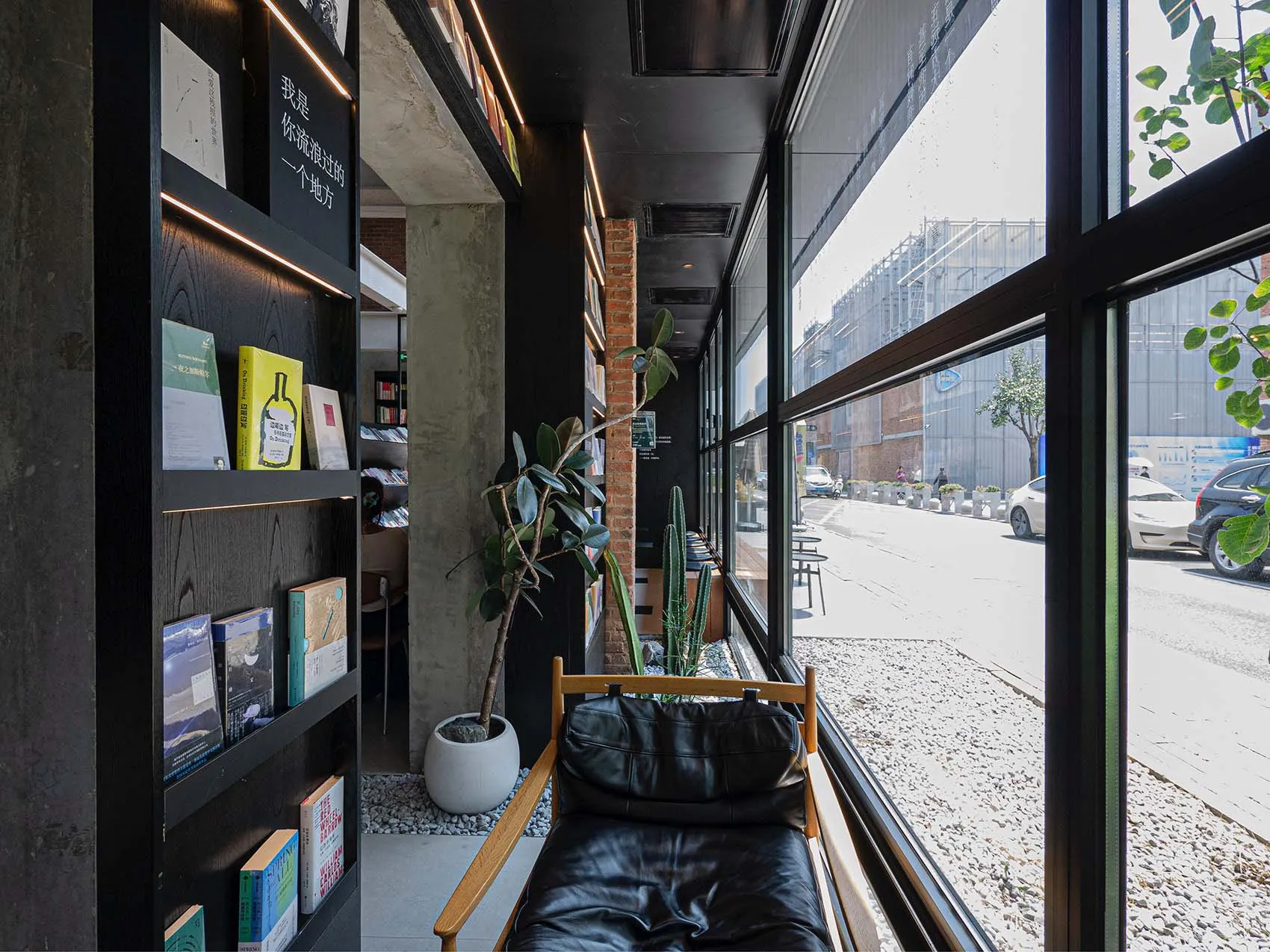 現代都市圖書館室內視圖,採用極簡設計,搭配黑色皮革家具、水泥牆面與大型