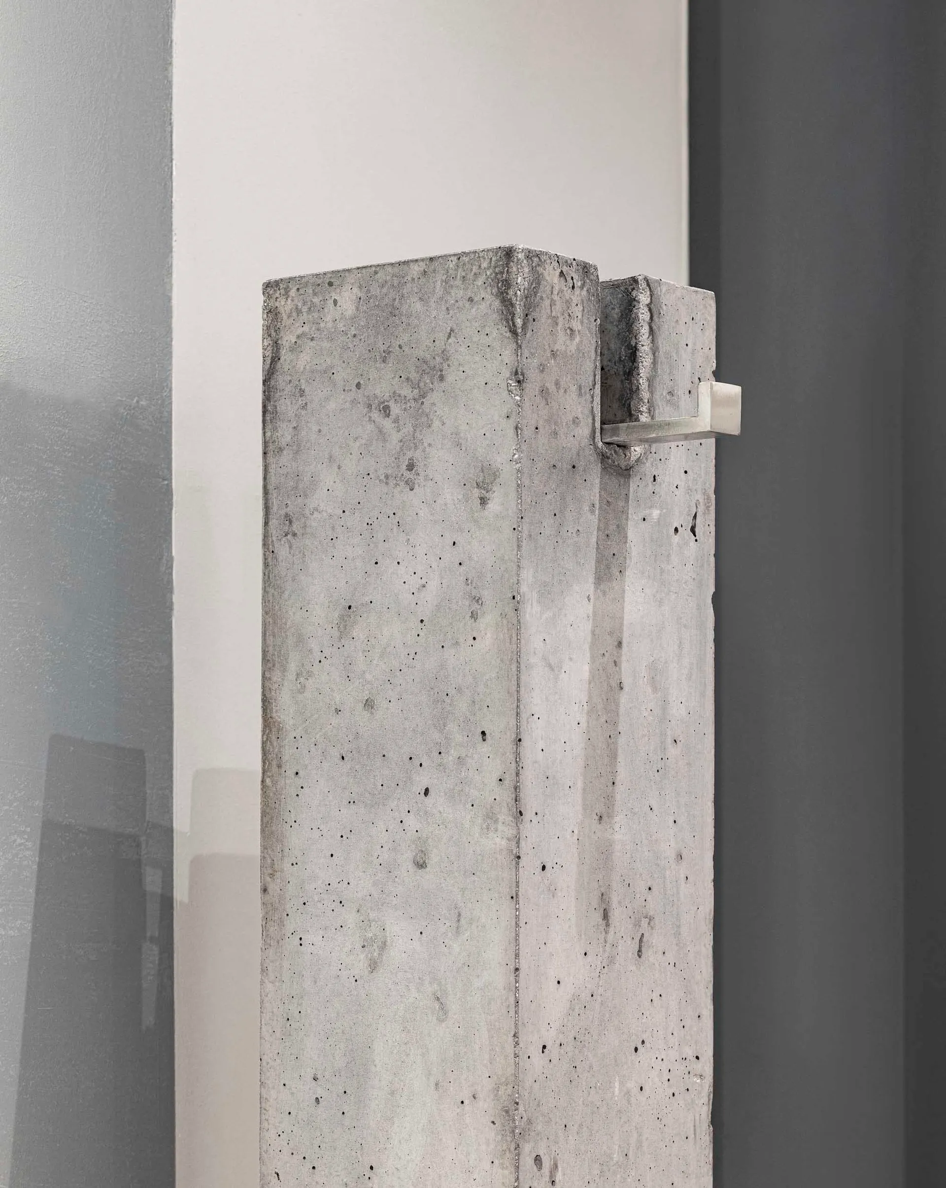 Modern living room with minimalist decor, featuring a concrete column as a central architectural element.