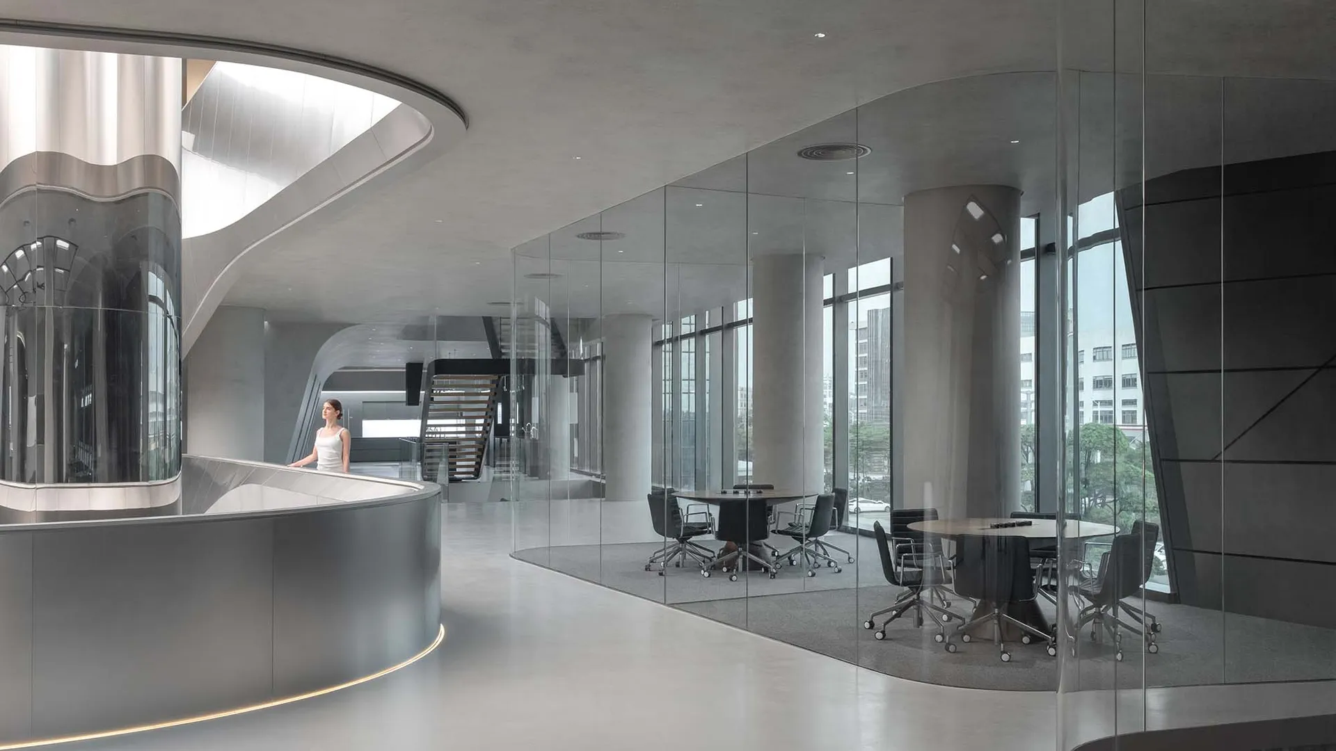 A modern conference room featuring glass walls and concrete columns.