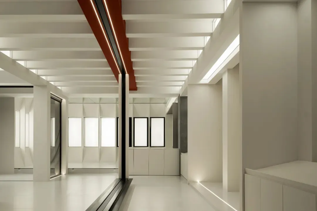 Modern office corridor featuring a white interior and metallic ceiling panels
