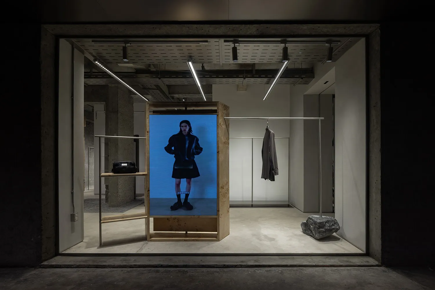 零售店面展示區設有數位螢幕，螢幕上模特兒正展示時尚服裝。