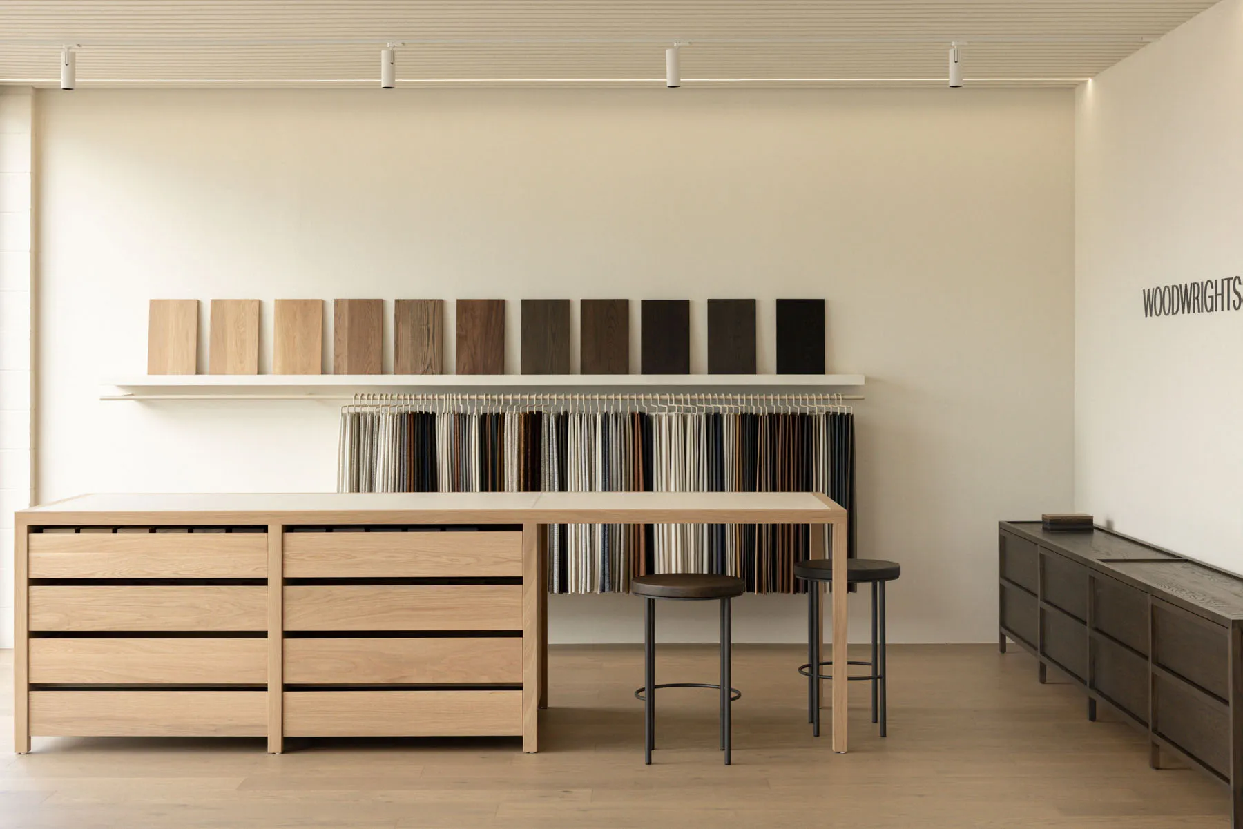 A minimalist showroom showcasing various wood finishes and materials.