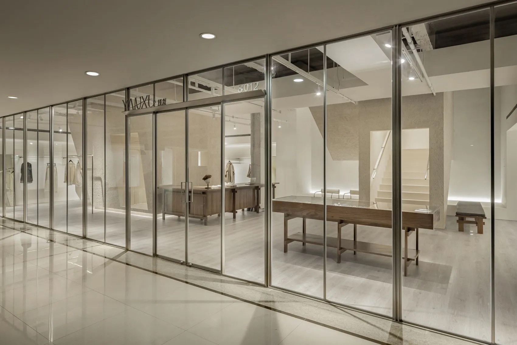 Modern retail storefront with glass window frame, concrete ceiling, and minimalist design