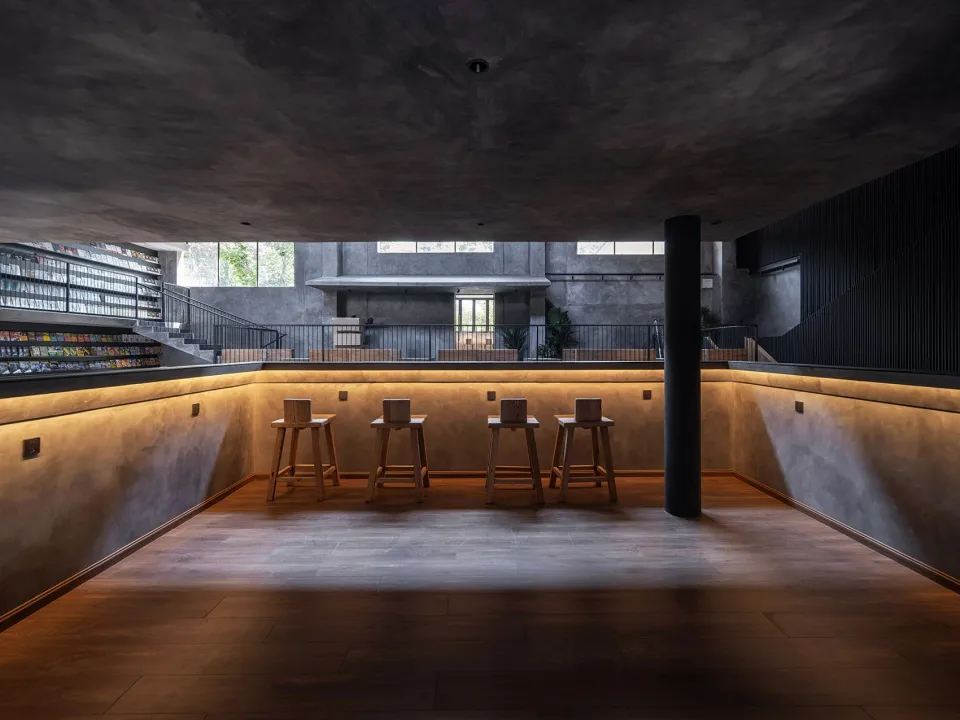 A modern bar area with concrete seating and warm lighting.