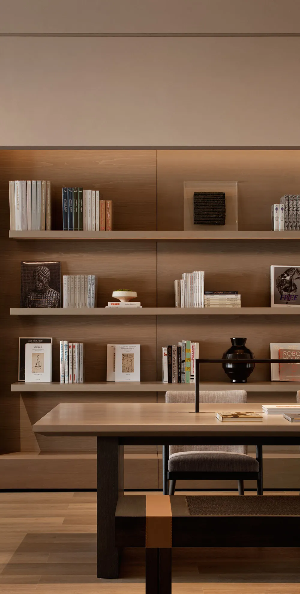 A modern home library with wooden shelves and stone accents.