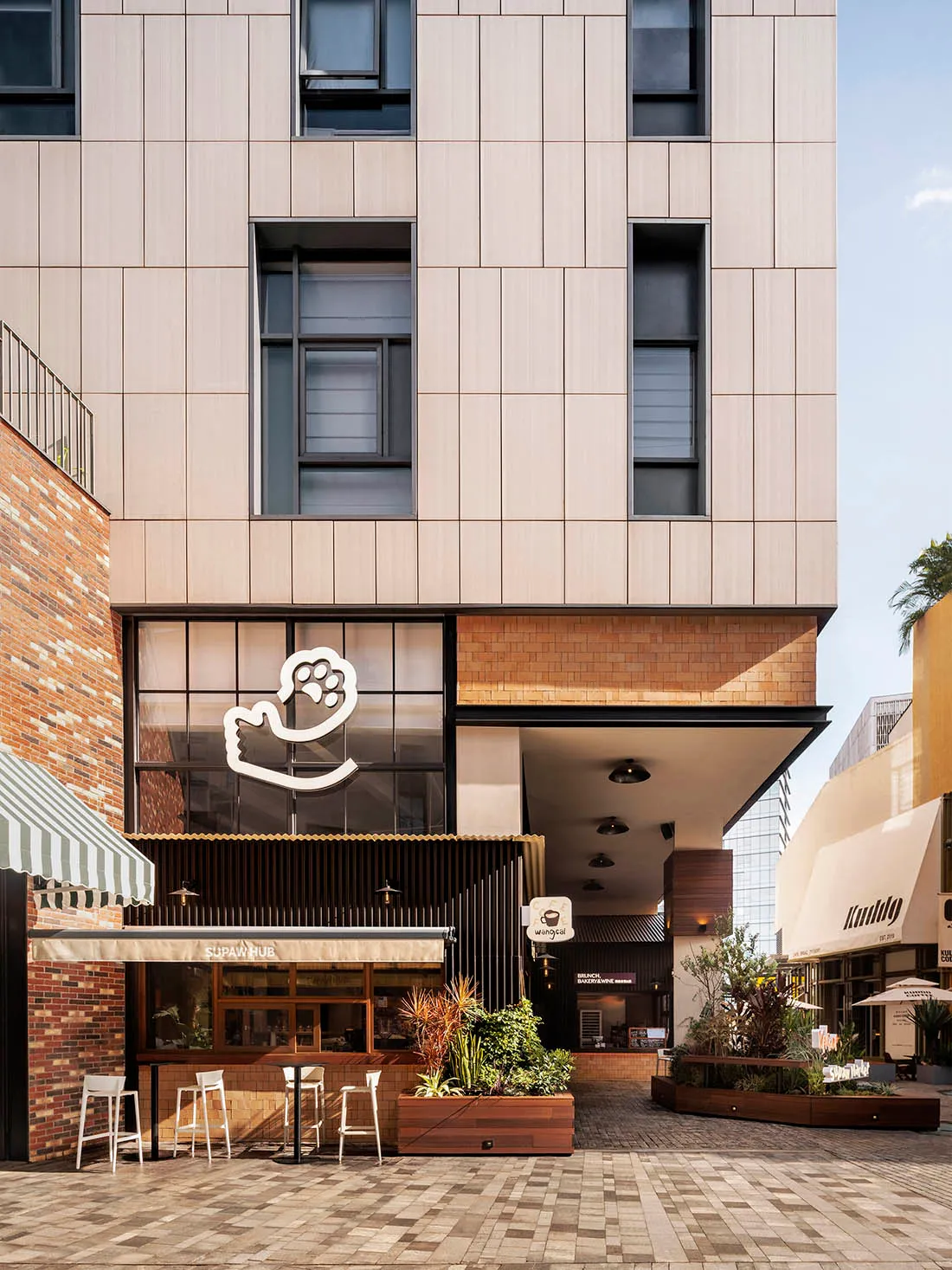 A modern retail storefront featuring brick, concrete, and wooden elements.