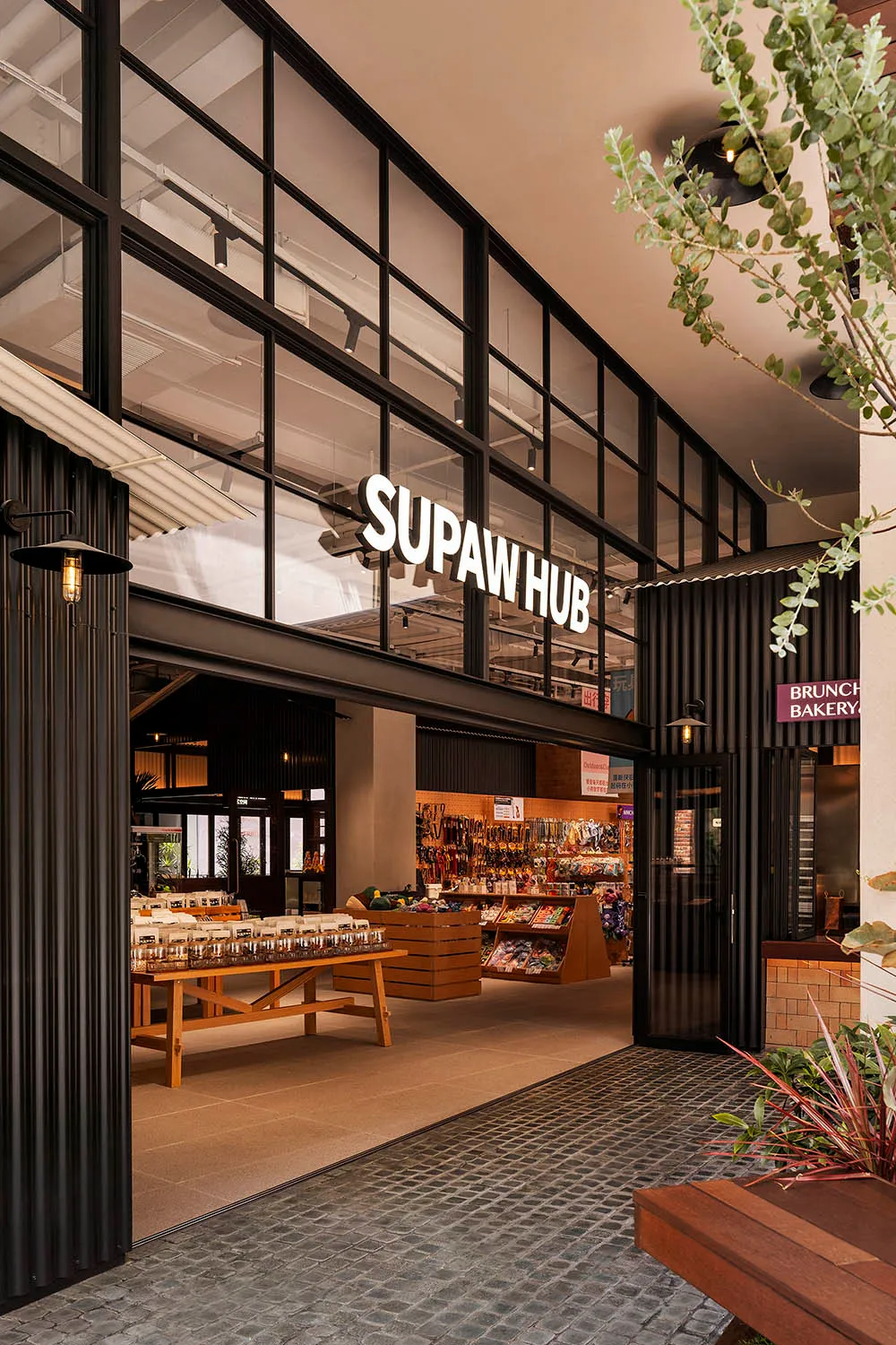 Modern storefront with large glass windows and signage reading 'SUPAW HUB'.